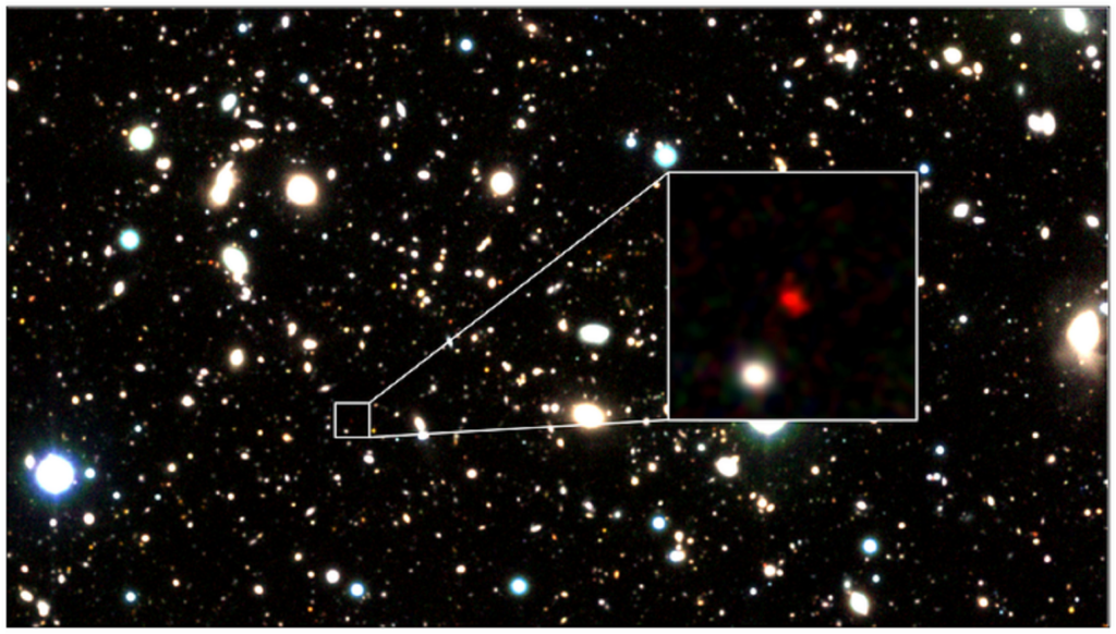 Zoomed-in telescope image of distant galaxies and stars with a red one labeled as HD1