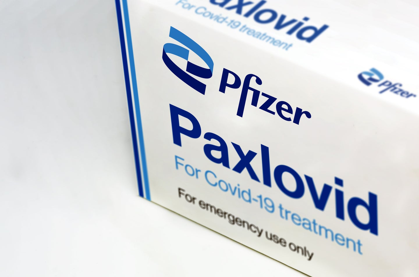 a white and blue medicine box that reads paxlovid by pfizer