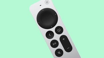 Apple TV remote against a green background