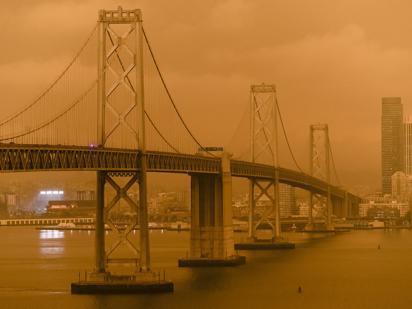Smoke from wildfires in California covers the San Francisco - Oakland Bay Bridge and buildings on the San Francisco skyline.