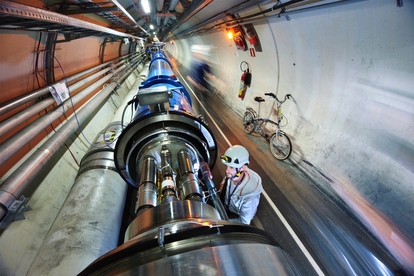 CERN worker examining semiconducting magnets of Large Hardon Collider accelerator