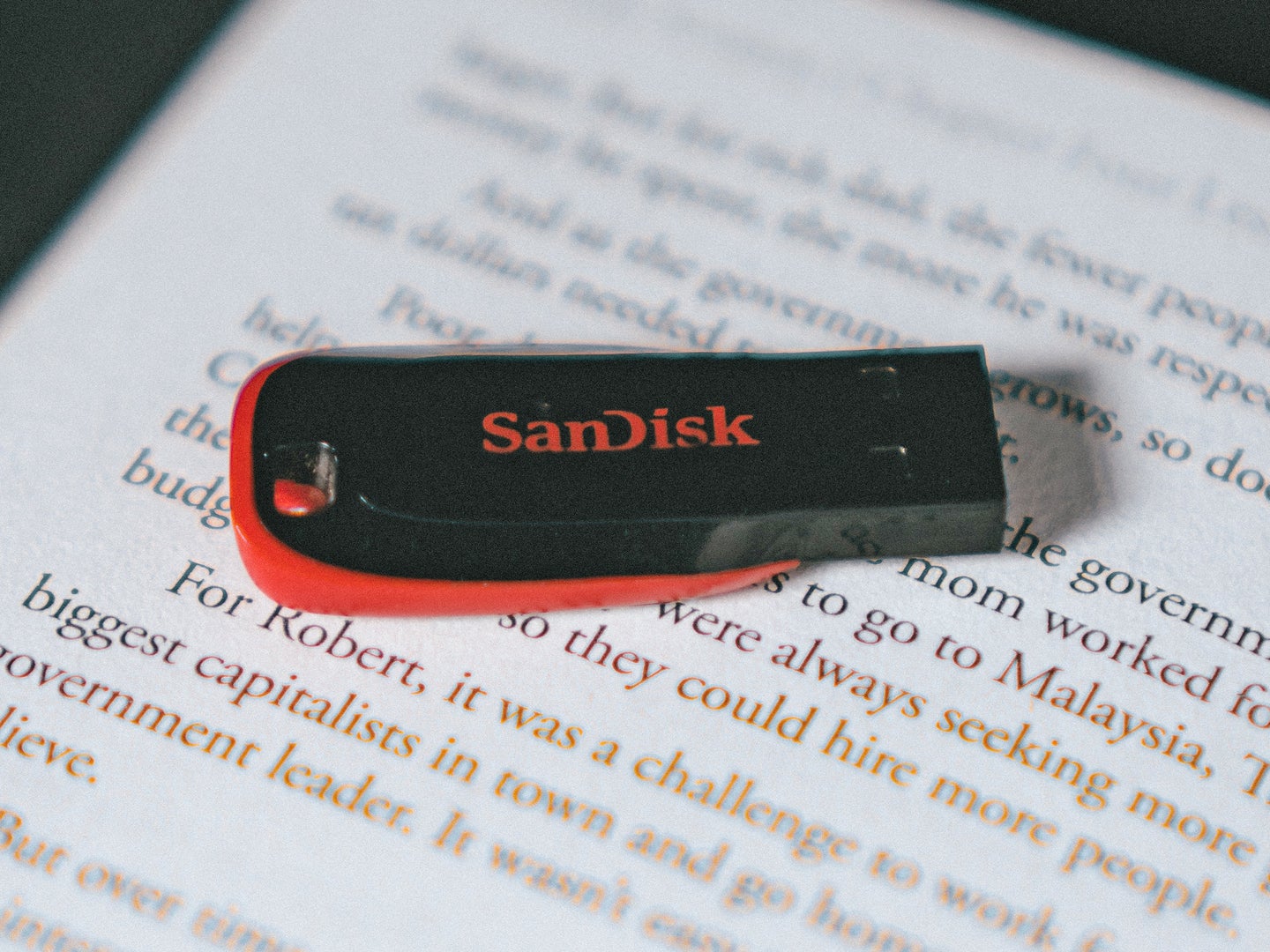 A SanDisk USB drive on top of an e-reader.