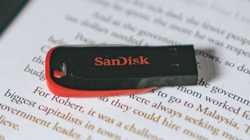 A SanDisk USB drive on top of an e-reader.