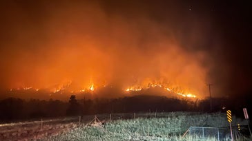 A fire moving across a hillside at night