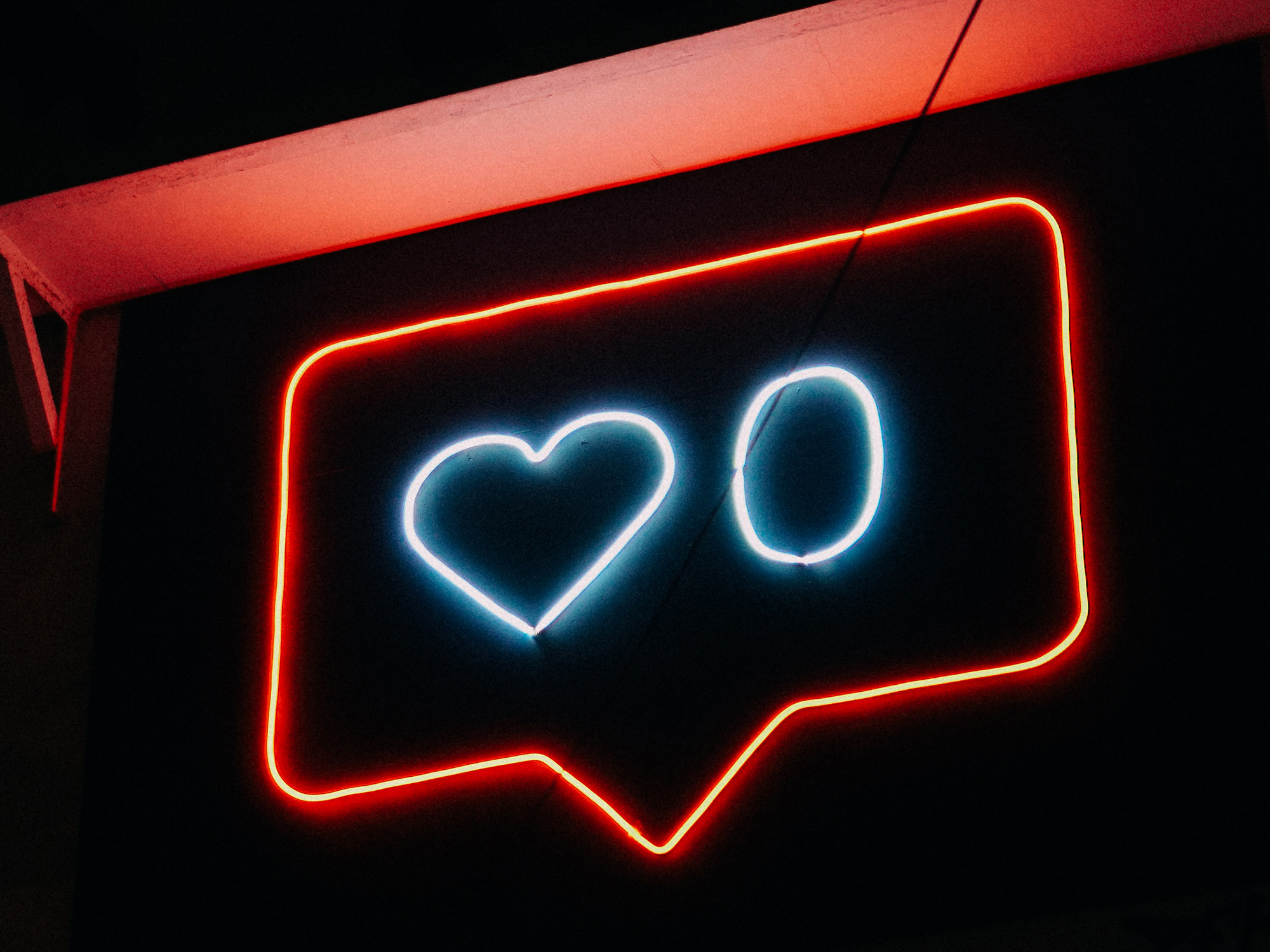 neon sign depicting an instagram like notification bubble with a zero