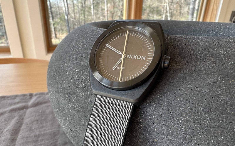 black NIXON Light-Wave A1322 watch set on a stone
