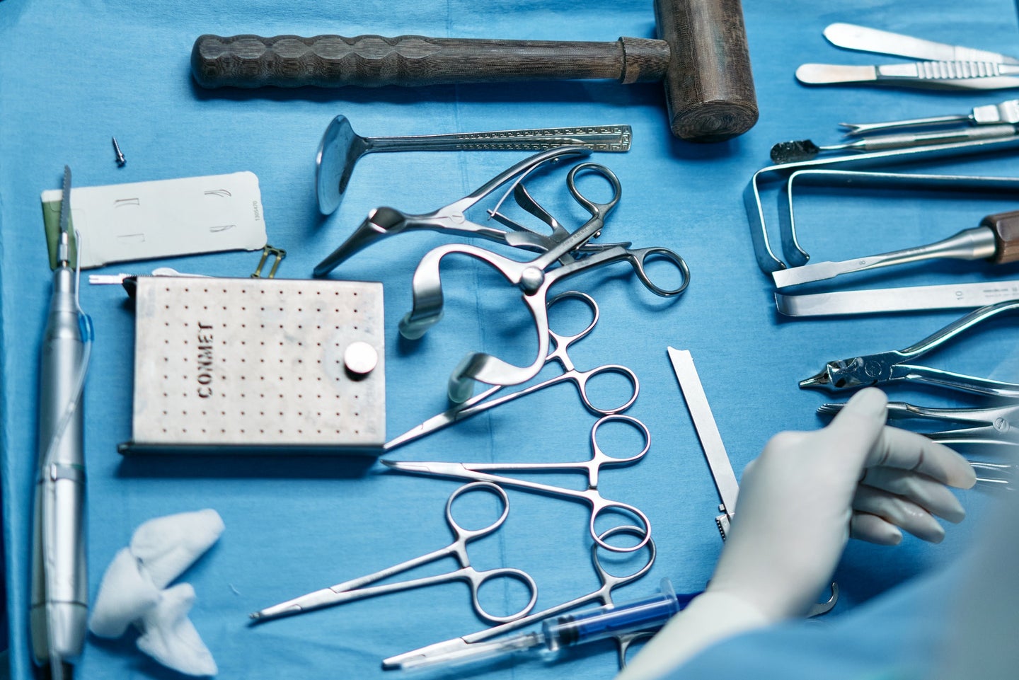 Surgical tools on blue backdrop.