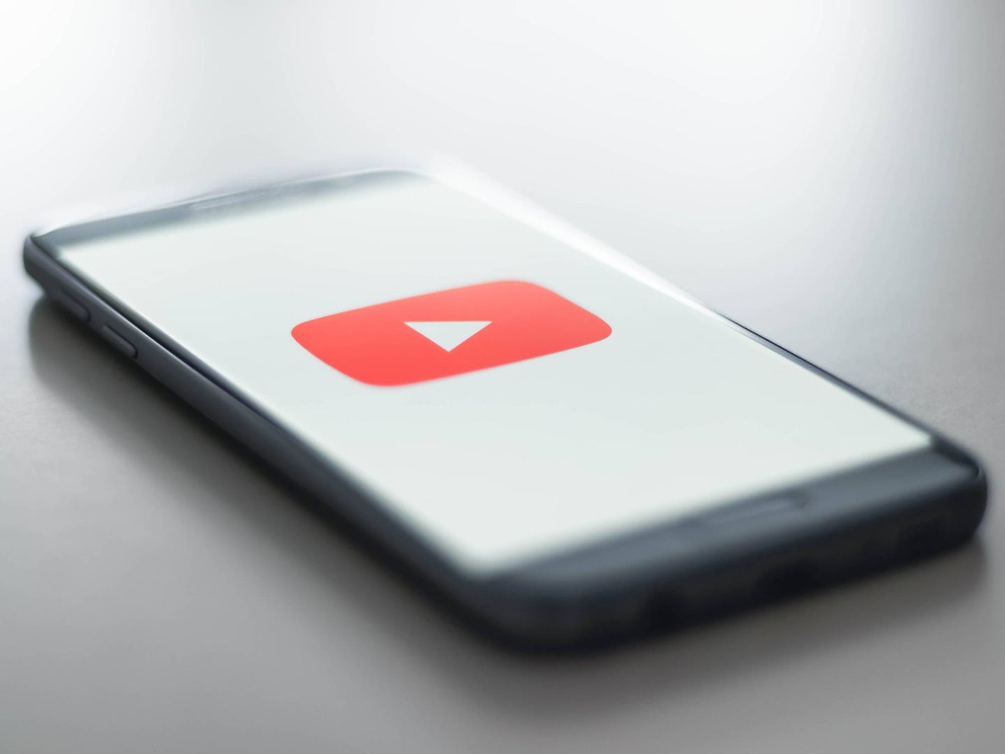 Smartphone-on-desk-with-youtube-logo-on-screen
