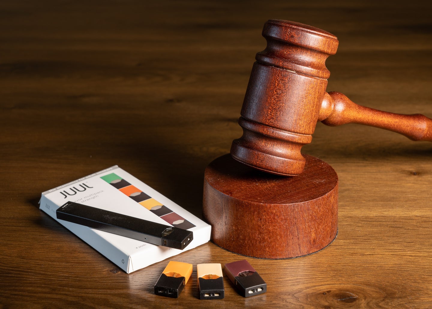 Juul e-cigarette vaping pen next to box and a gavel to symbolize FDA ban decision