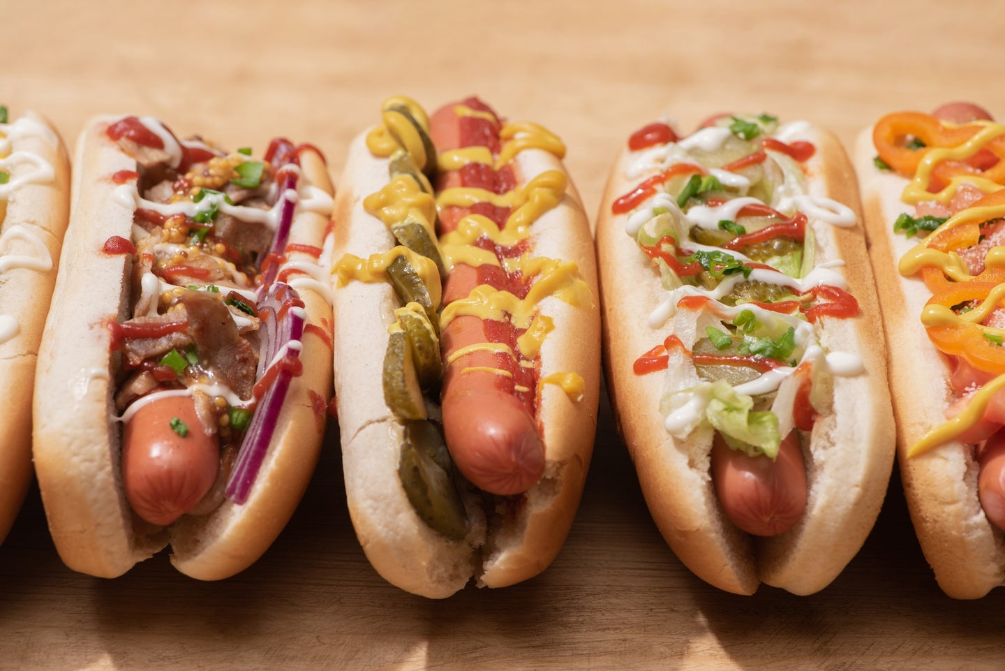 Hot dogs in buns with ketchup, mustard, and other toppings