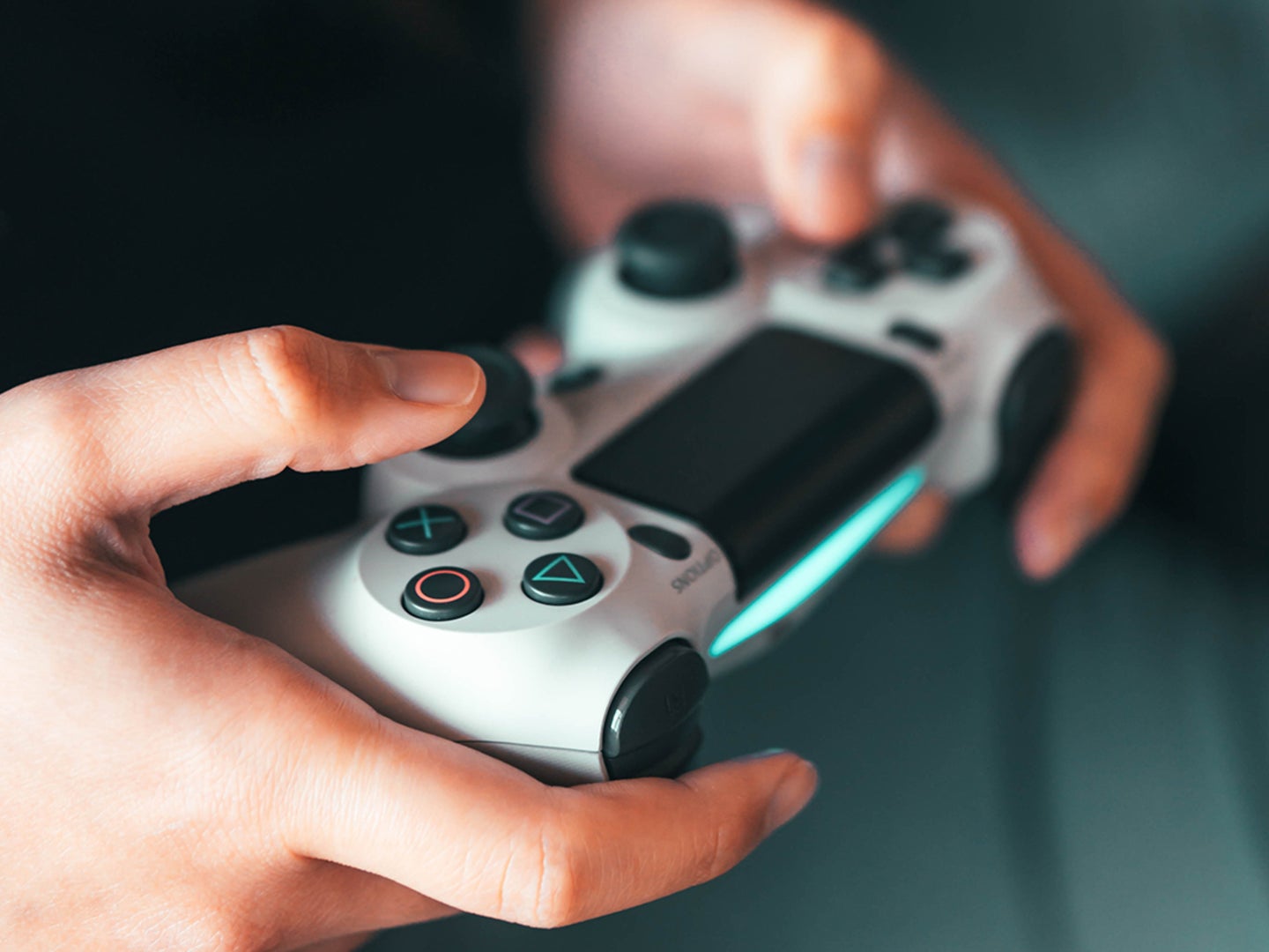 A close-up of a person holding a Playstation 5 controller