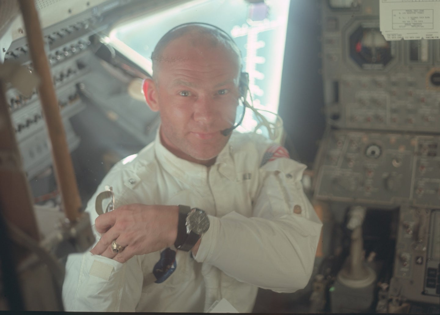 NASA astronaut Buzz Aldrin on Apollo 11 in a white uniform looking at camera