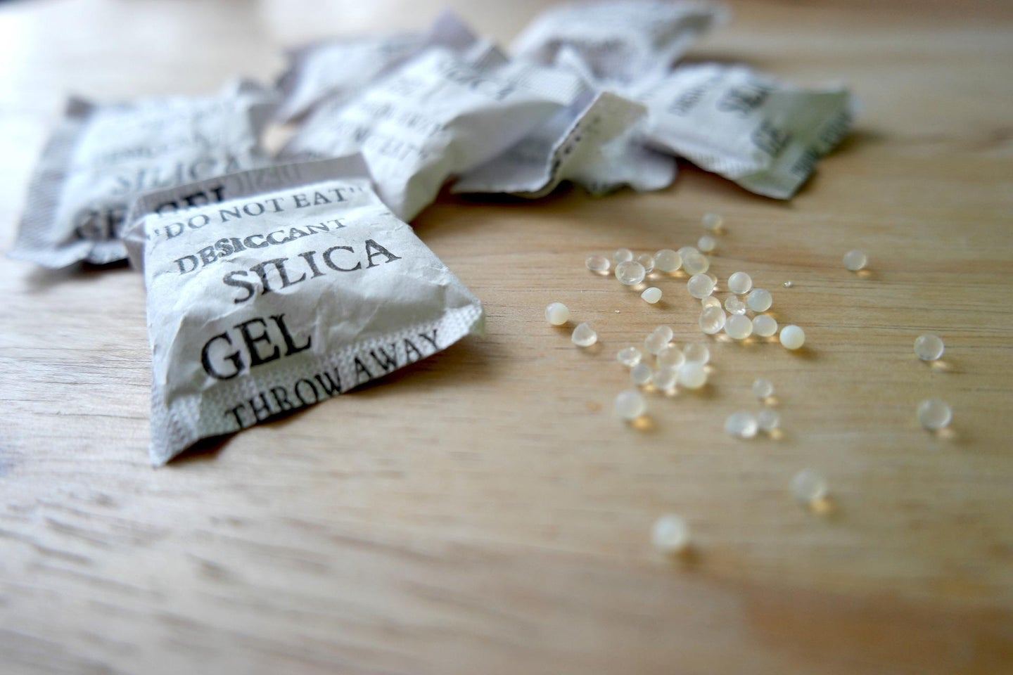 Opened silica gel packet on a wood countertop, ready for someone to find another use for them.