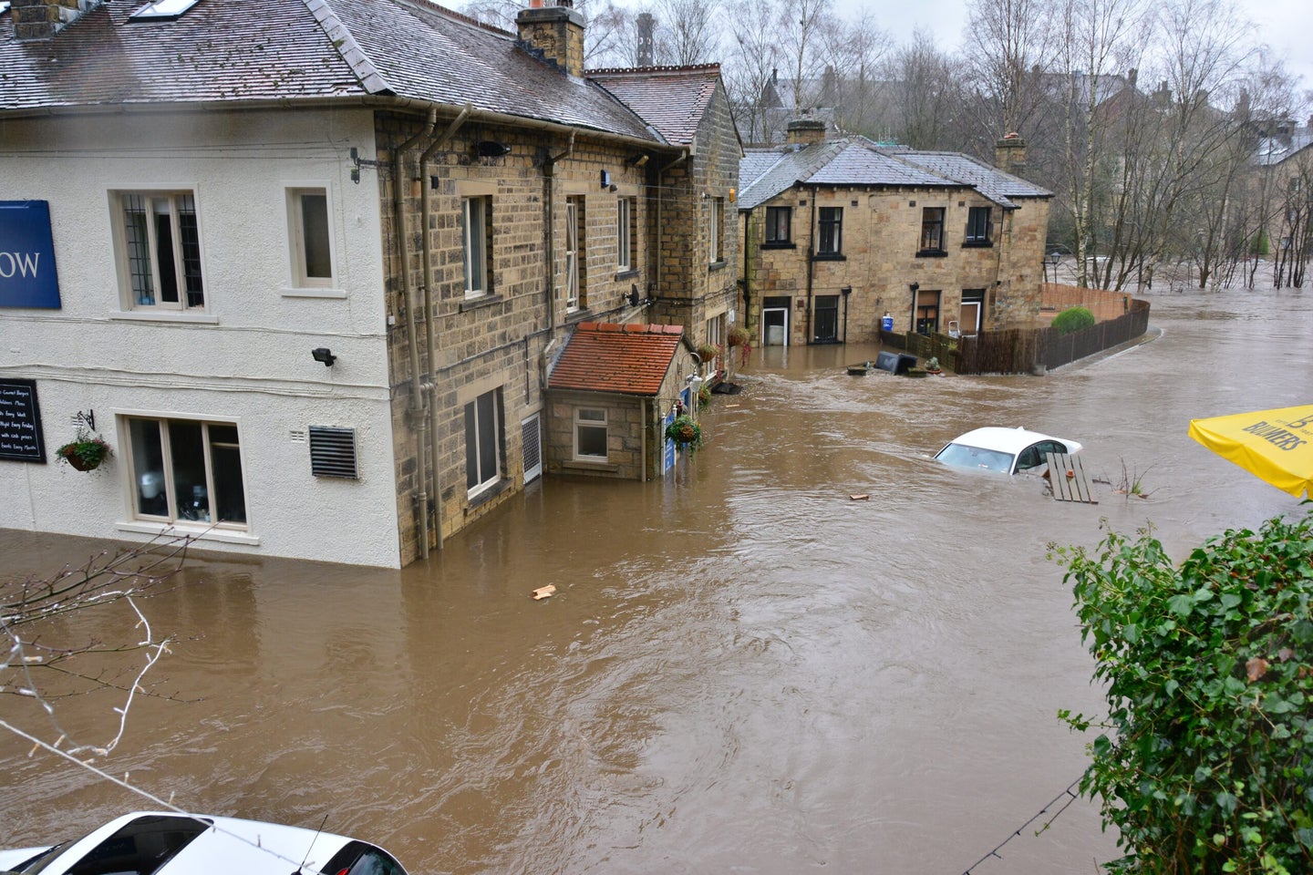 Flooded buildings and cars in neighborhood.