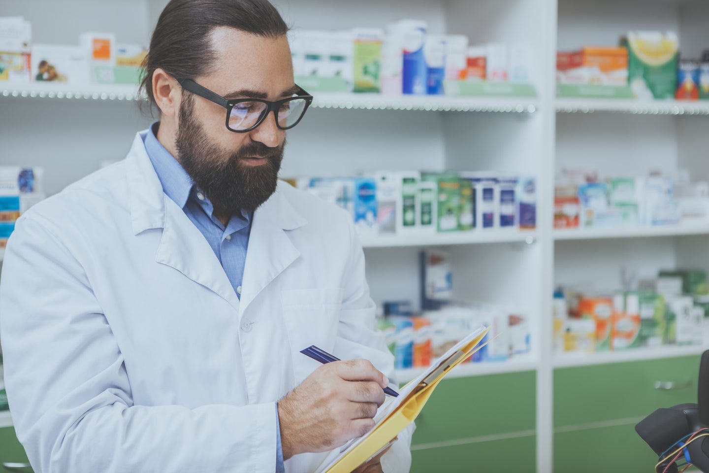 Pharmacist in white jacket with brown beard and thick glasses denying a prescription for contraceptives after abortion ban