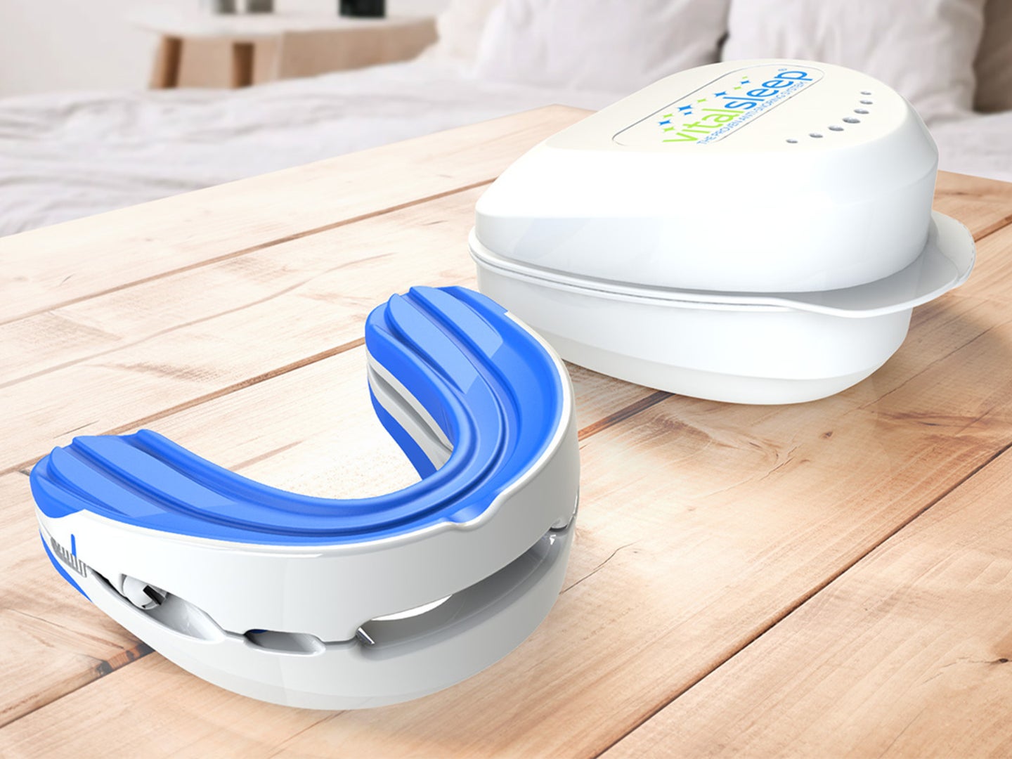 A snoring mouthguard sits on a wooden tray that's placed on a bed