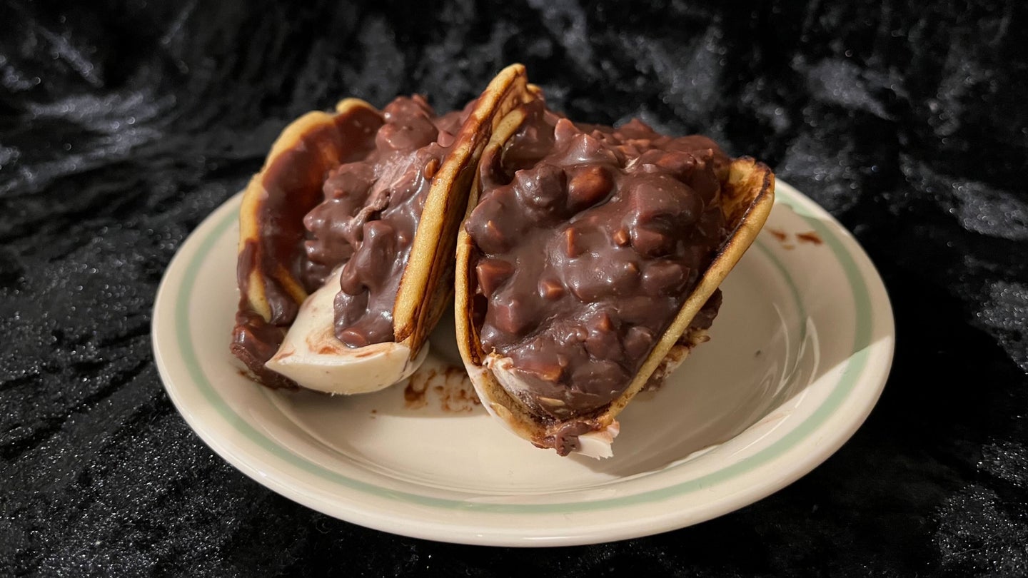 A pair of homemade Choco Tacos on a white plate in front of a black velvet background.