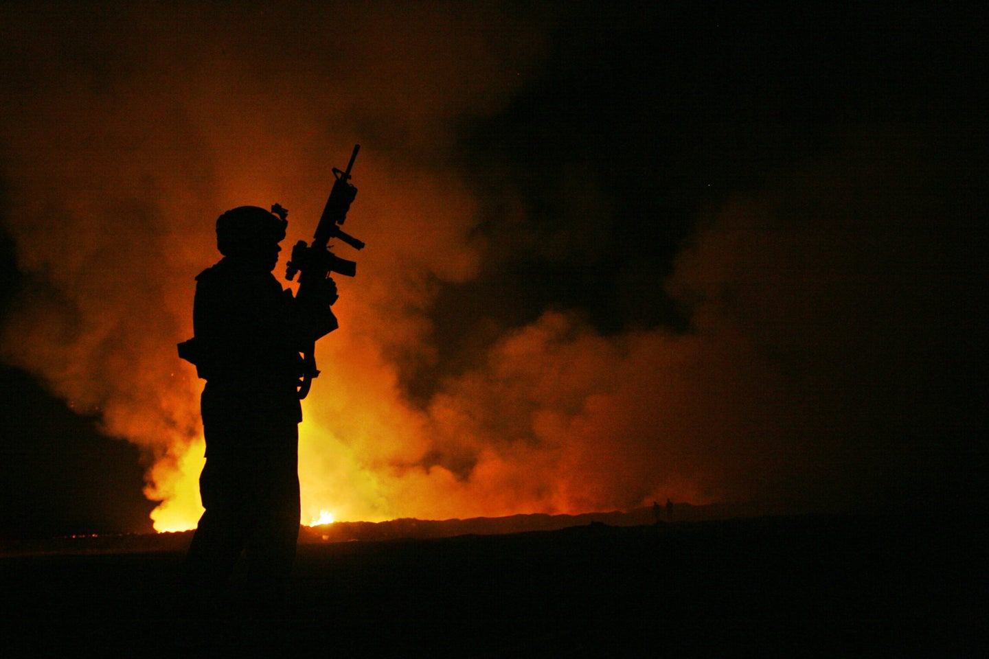 A Marine sergeant watches over a burn pit in Fallujah, Iraq, in 2007.