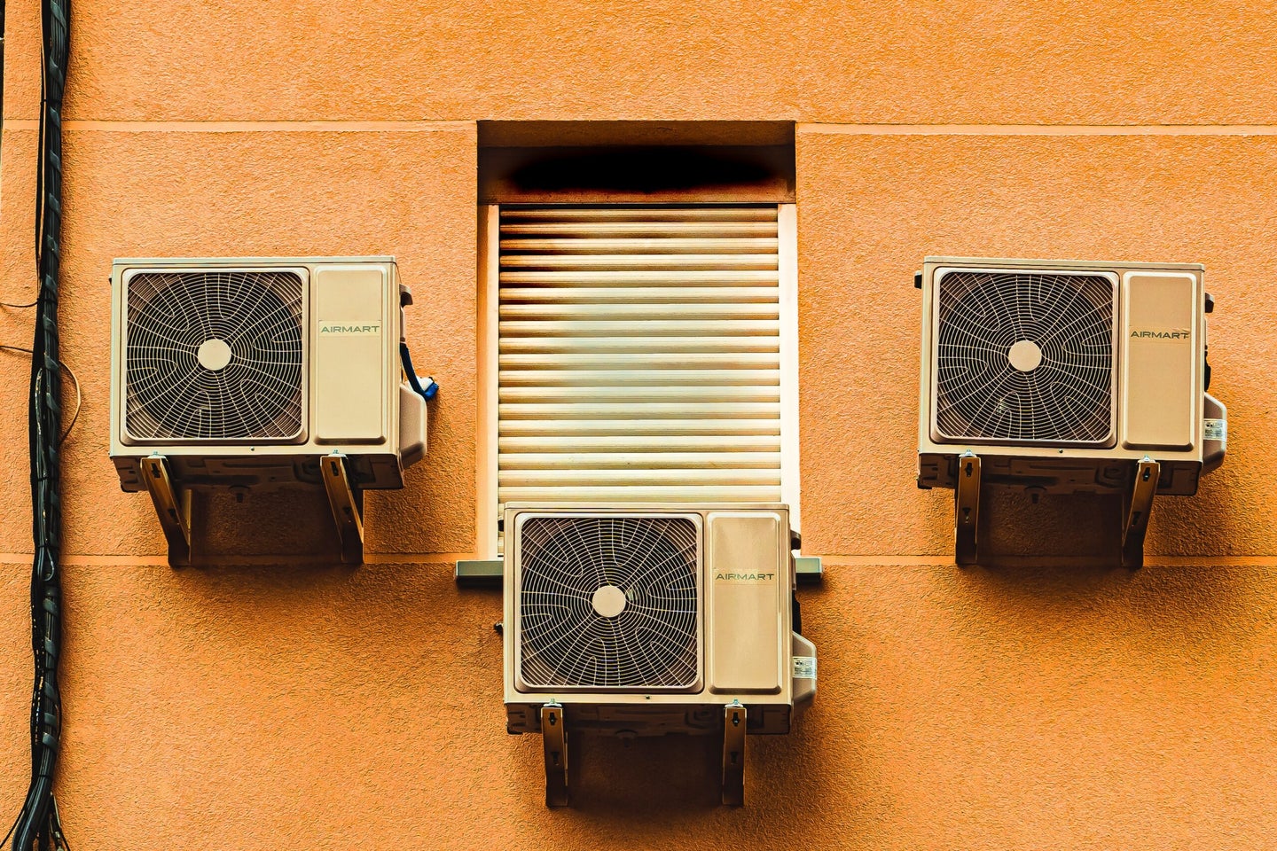Air conditioning units on orange wall.