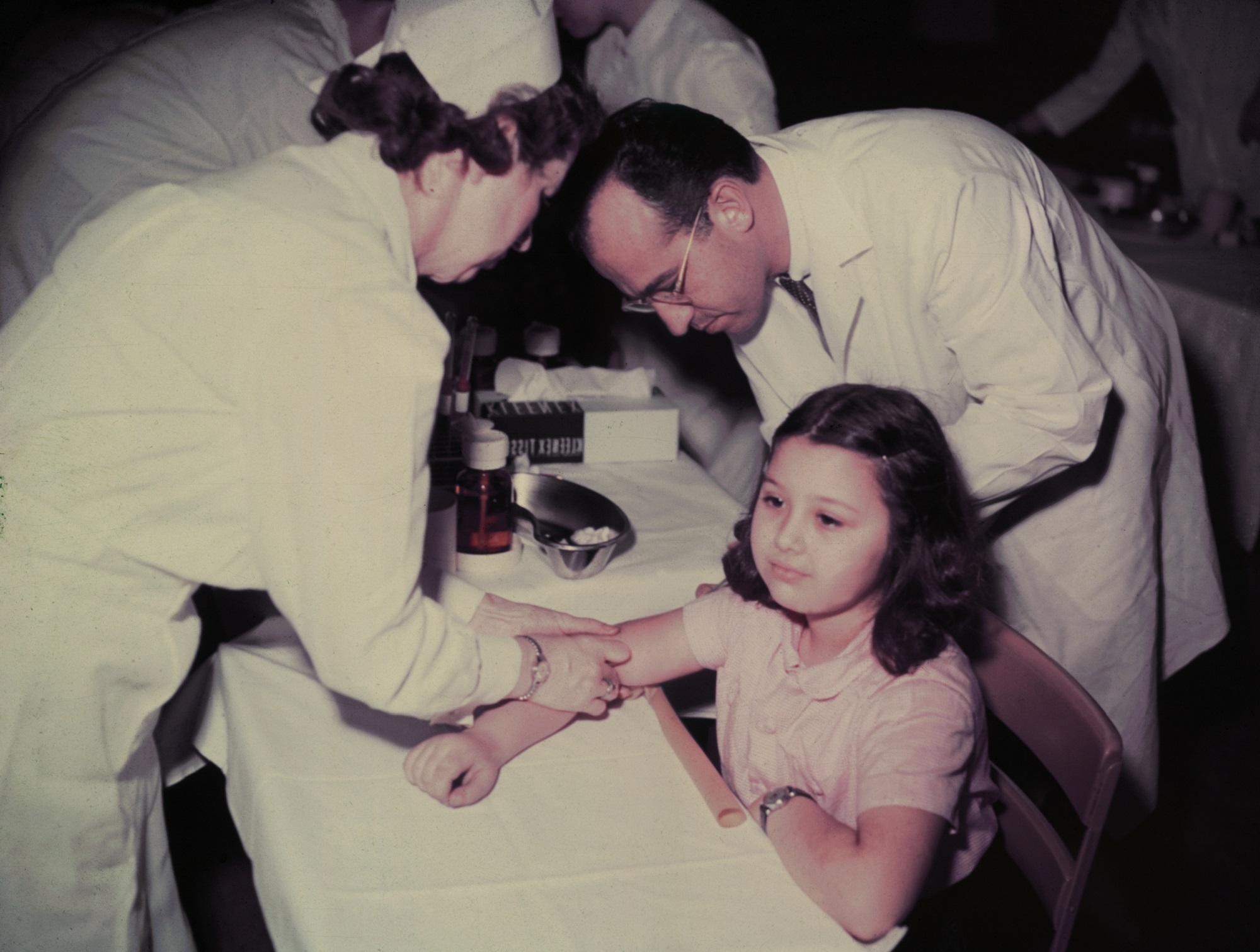 At right, Jonas Salk, the doctor behind the first polio vaccine, administers a shot to a kid in Pennsylvania in 1955.