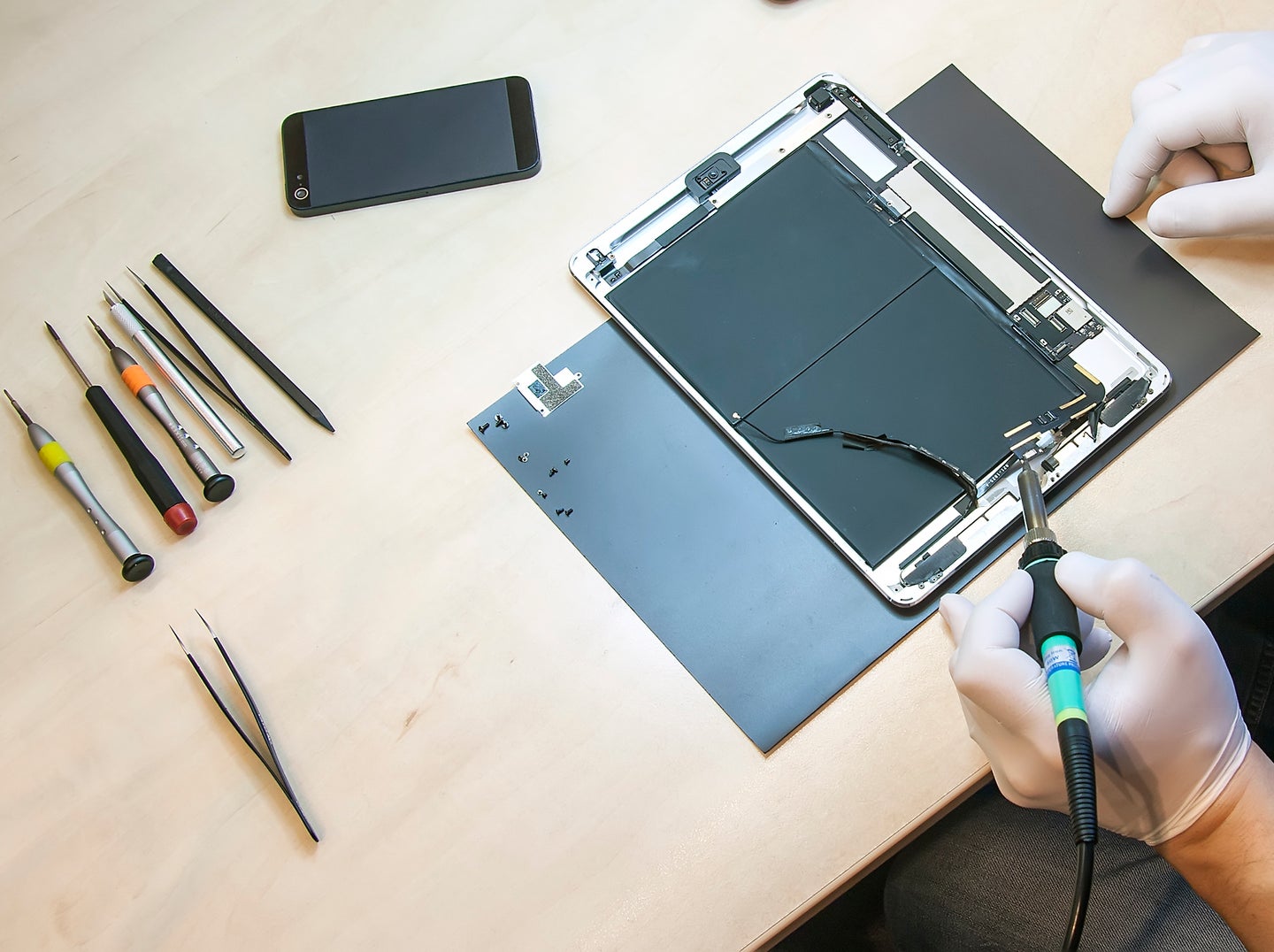 Overhead shot of person repairing iPad on desk