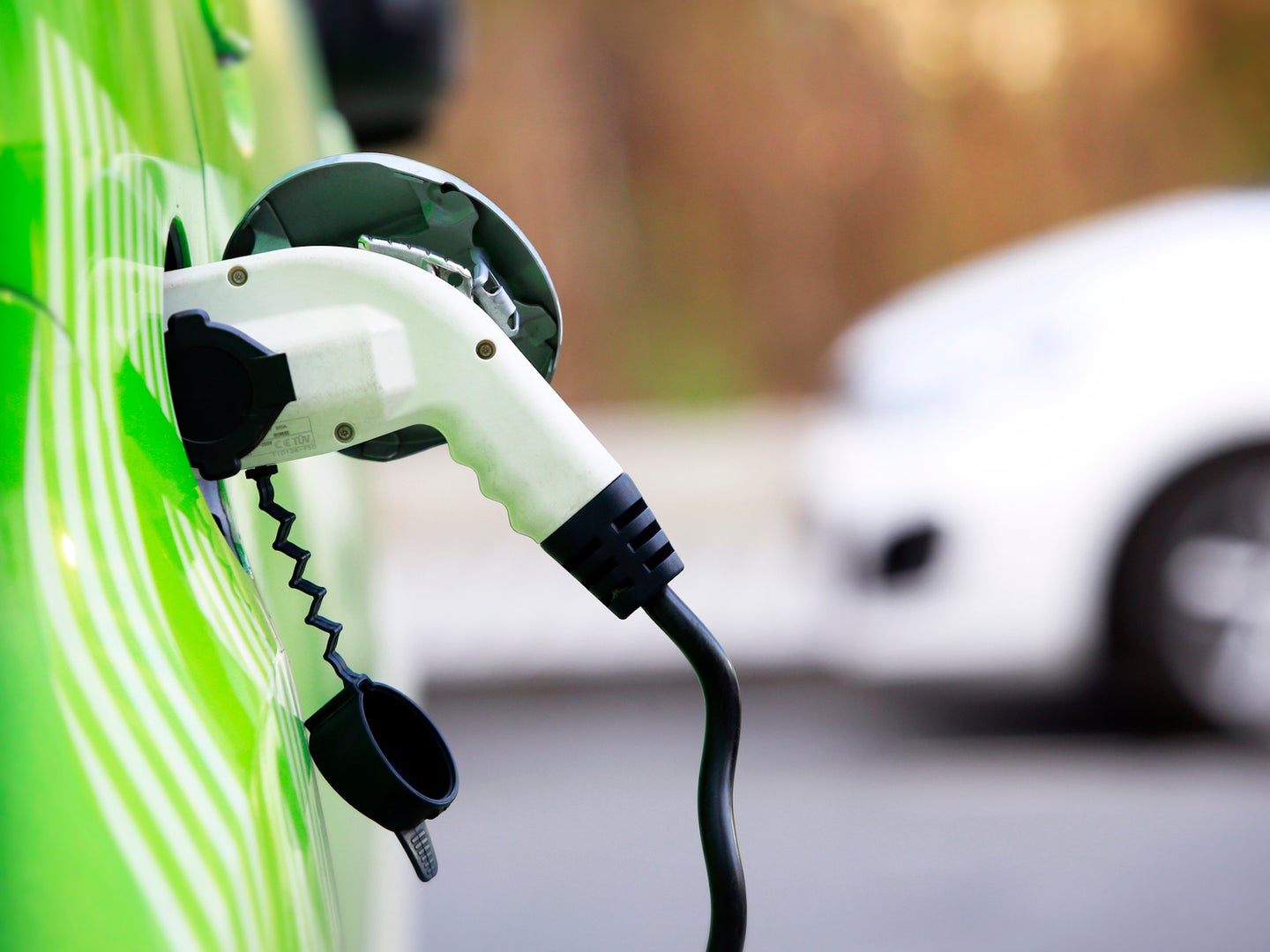 Close up of electric vehicle charger plugged into electric car