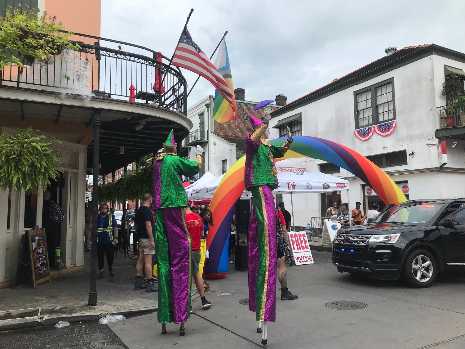 Bourbon Street, New Orleans monkeypox vaccine clinic with clowns on stilts and Pride flags waving