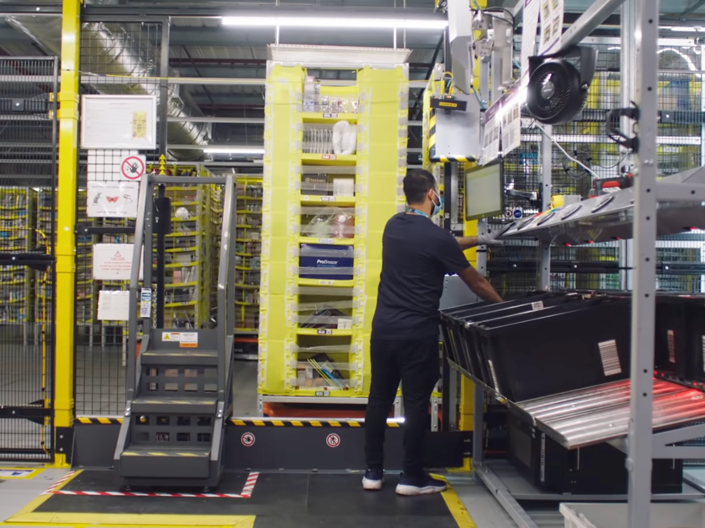 Screenshot of worker in front of shelf within Amazon warehouse