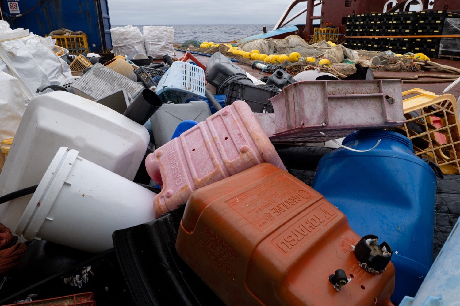 a pile of plastic crates, gasoline boxes, and other debris