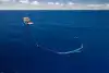 a ship pulling a u-shaped apparatus in the ocean