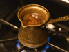 ibrik over the stove with foaming coffee