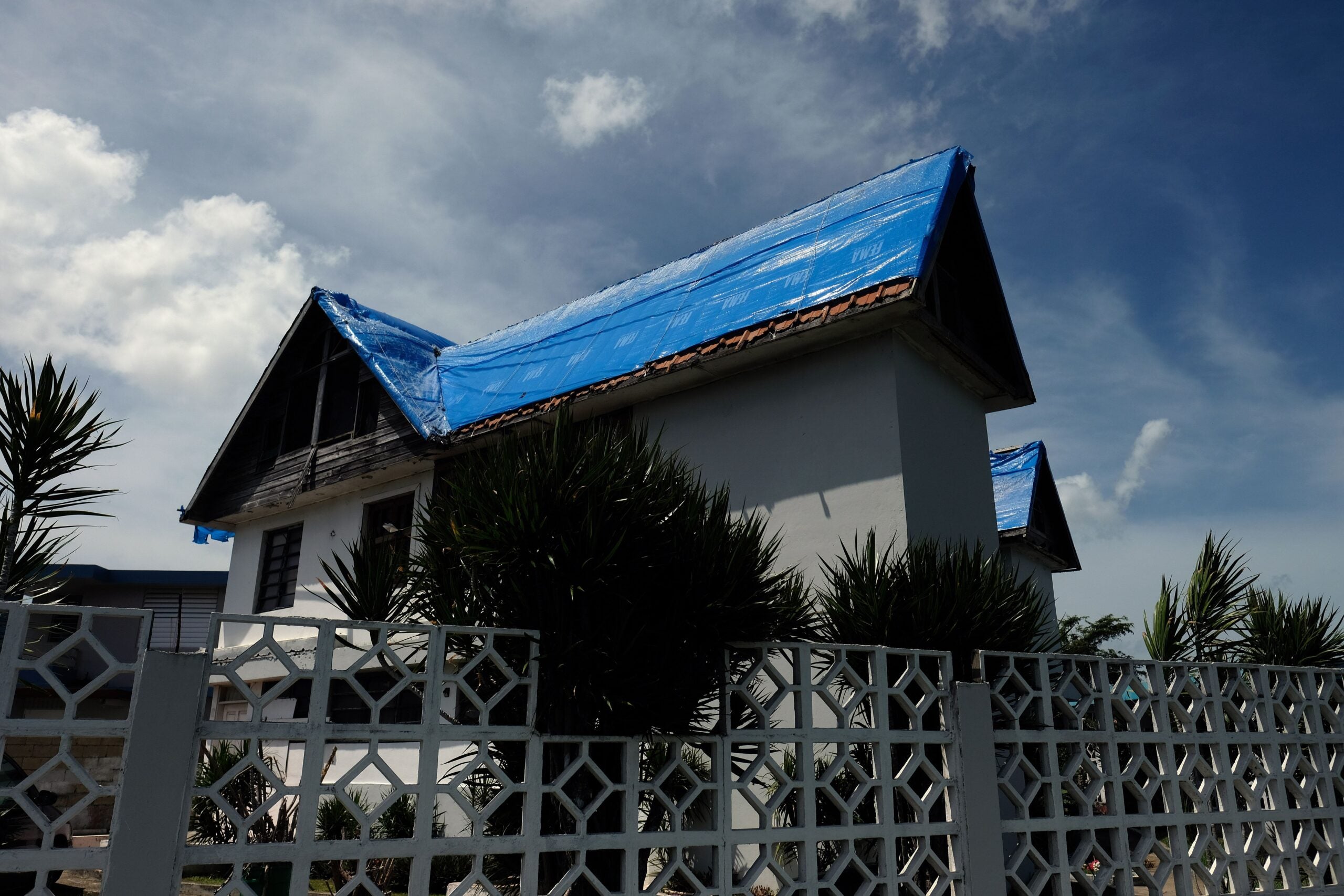 The blue tarp that was used to protect the roof damaged by Hurricane Maria two years ago is showing wear and tear in Toa Baja, Puerto Rico, September 18, 2019. - Sixto Marrero gets goosebumps with each downpour. The roof of his house was razed two years ago by Hurricane Maria and replaced by a tarp that still protects him from the rain. His humble residence in a neighborhood in the heart of San Juan, the capital, is one of 30,000 that have the "blue roofs", as the awnings that the federal emergency agency FEMA gave to those who lost coverage of their homes in the disaster. (Photo by Ricardo ARDUENGO / AFP)        (Photo credit should read RICARDO ARDUENGO/AFP via Getty Images)