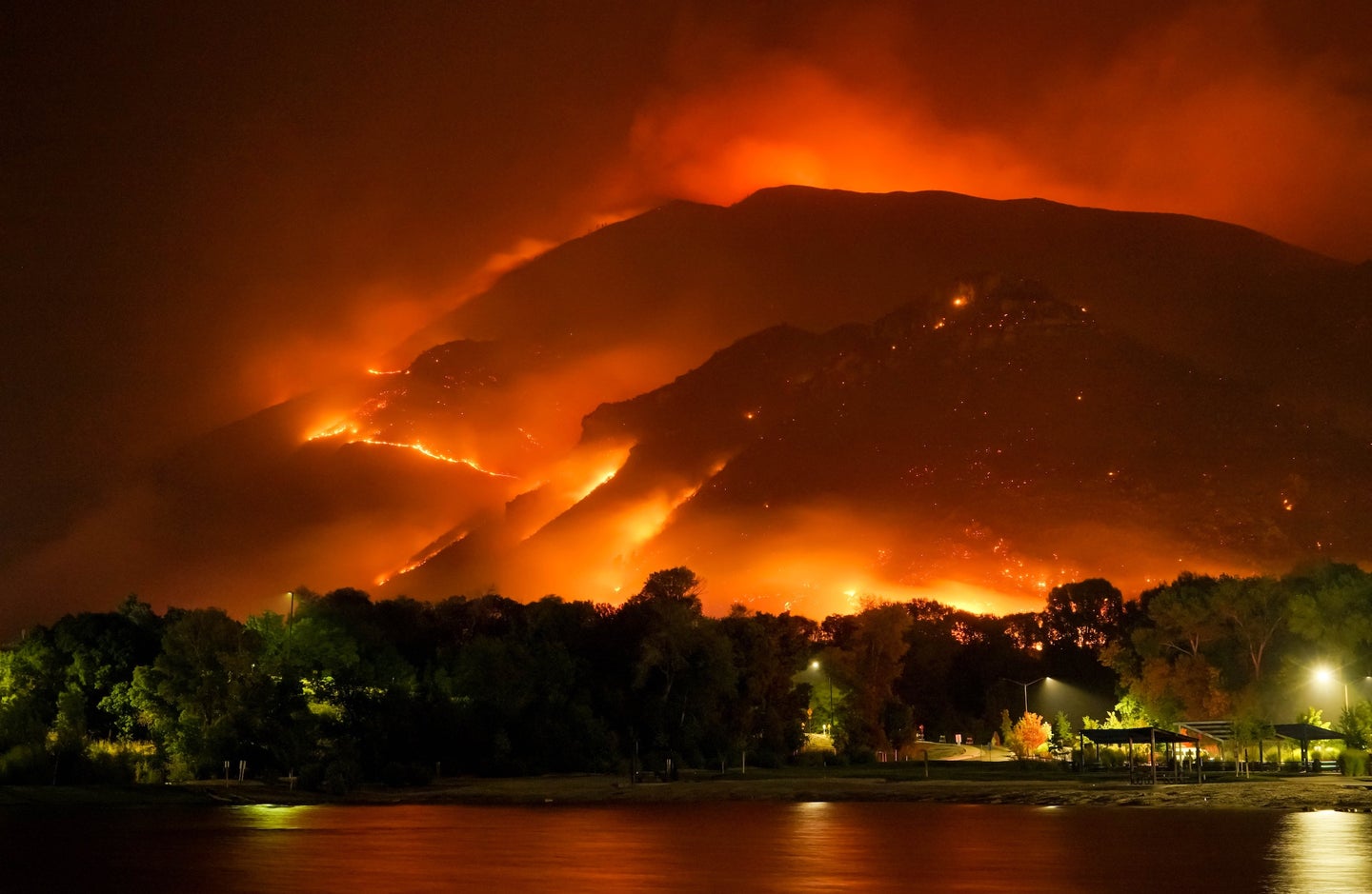 Photo of wildfires covering mountains with residential area below it