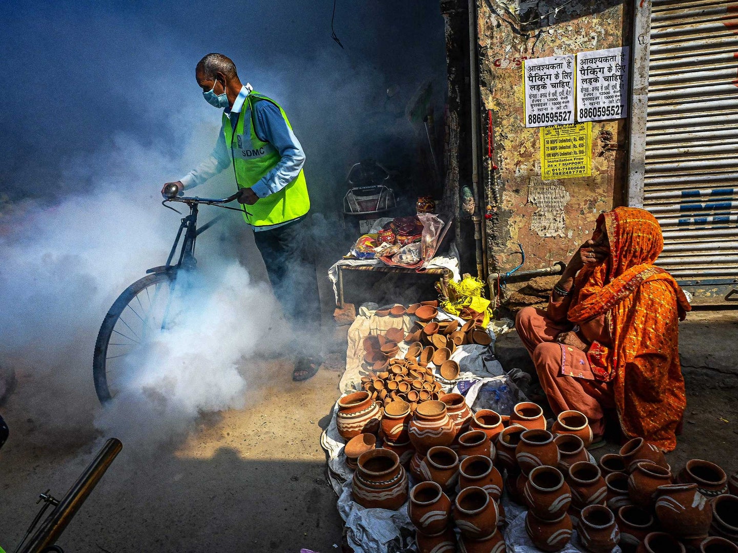 South Delhi Municipal Corporation (SDMC) workers fumigate an area to prevent mosquito breeding in New Delhi on October 27, 2021.