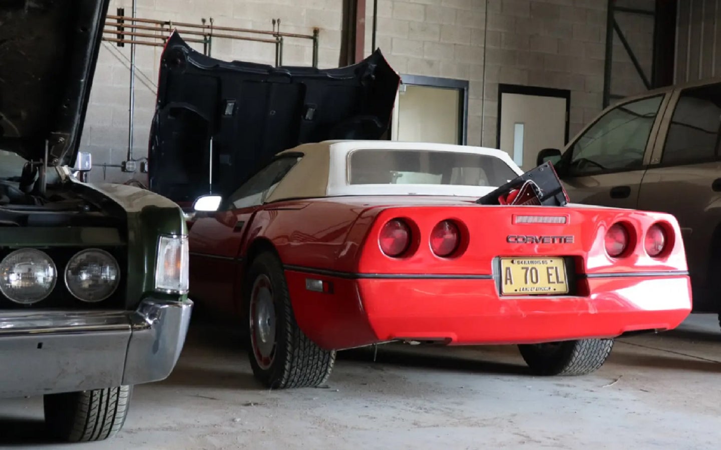 Red electric Chevy Corvette convertible prototype in a garage