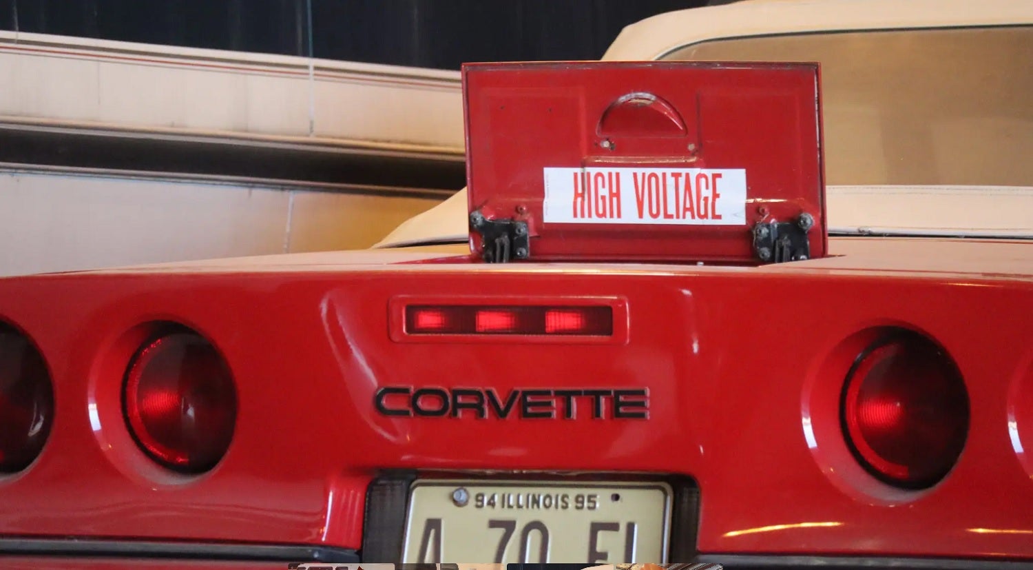 1978 electric Chevy Corvette in red with back charger cover that says "high voltage"