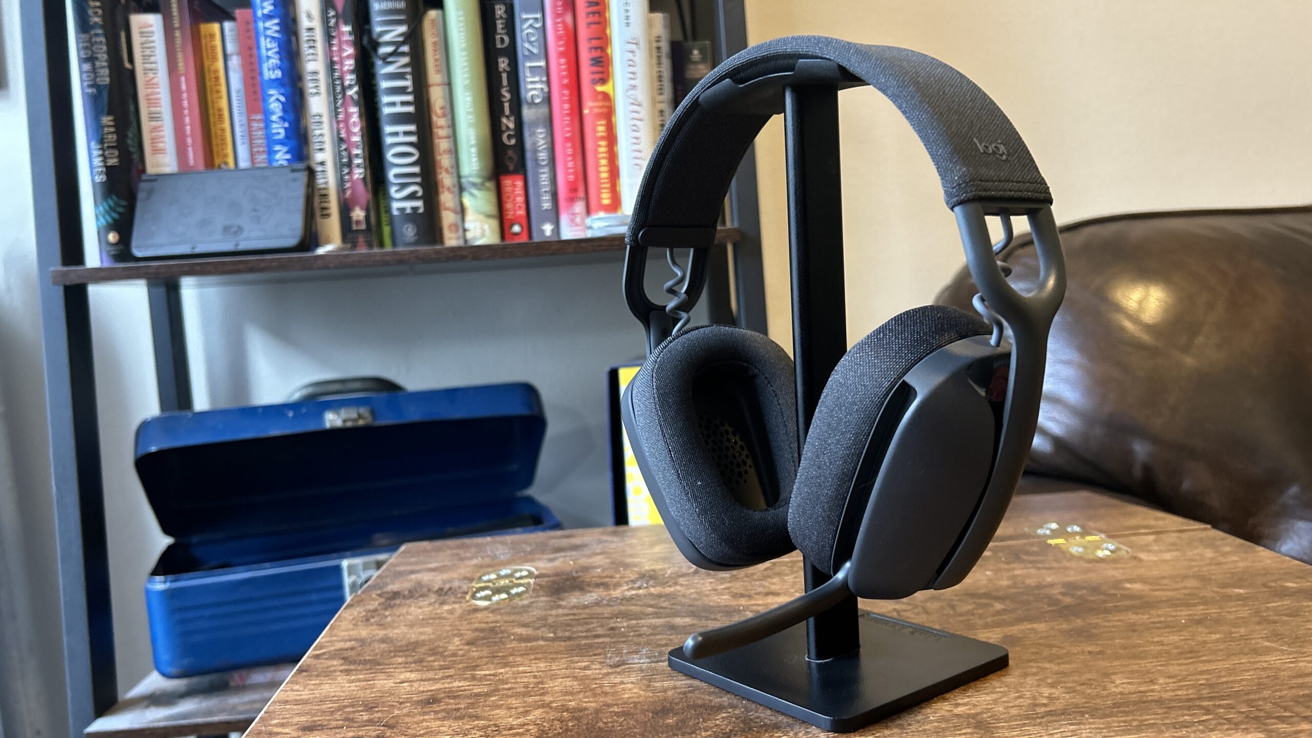 Logitech Zone Vibe 100 hanging on a headset sitting on a headphone stand