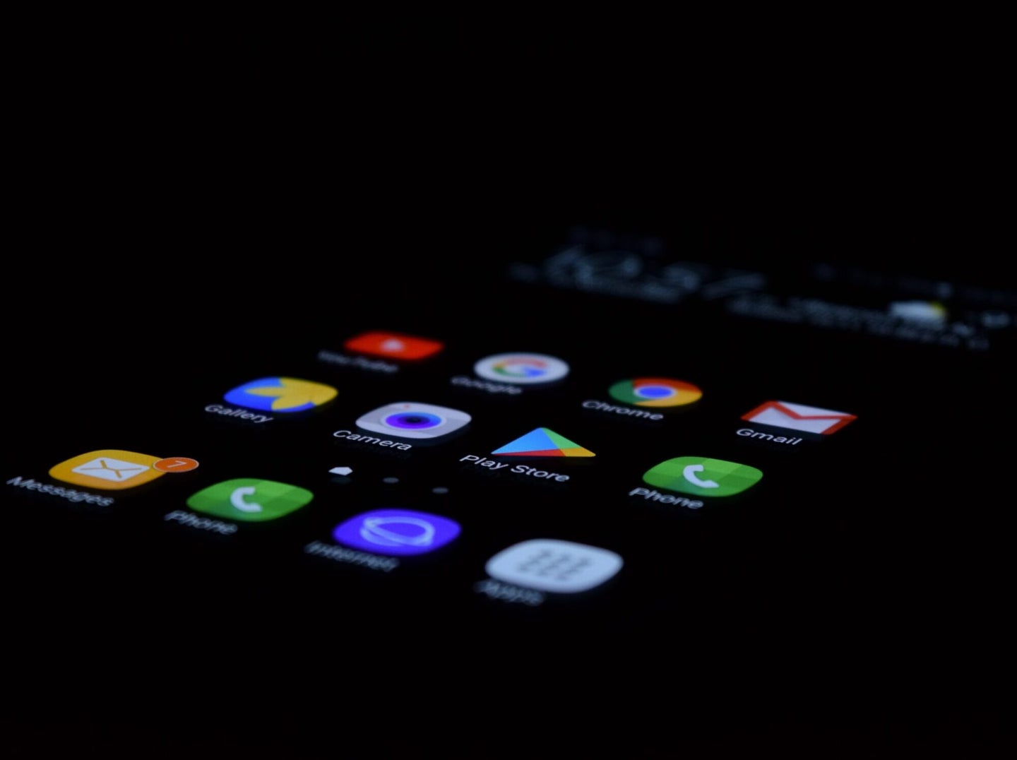 Backlit screen of smartphone home page displaying apps