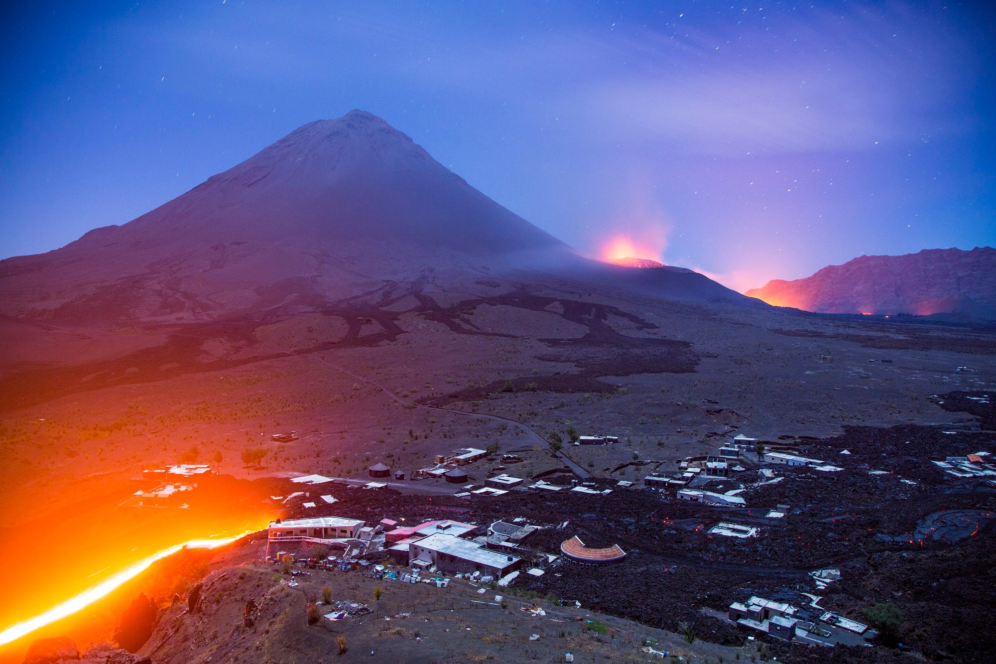 Lava flowing from Fogo volcano through villages at night