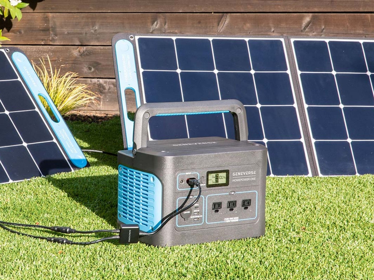 A solar generator on a patch of grass being powered by solar panels