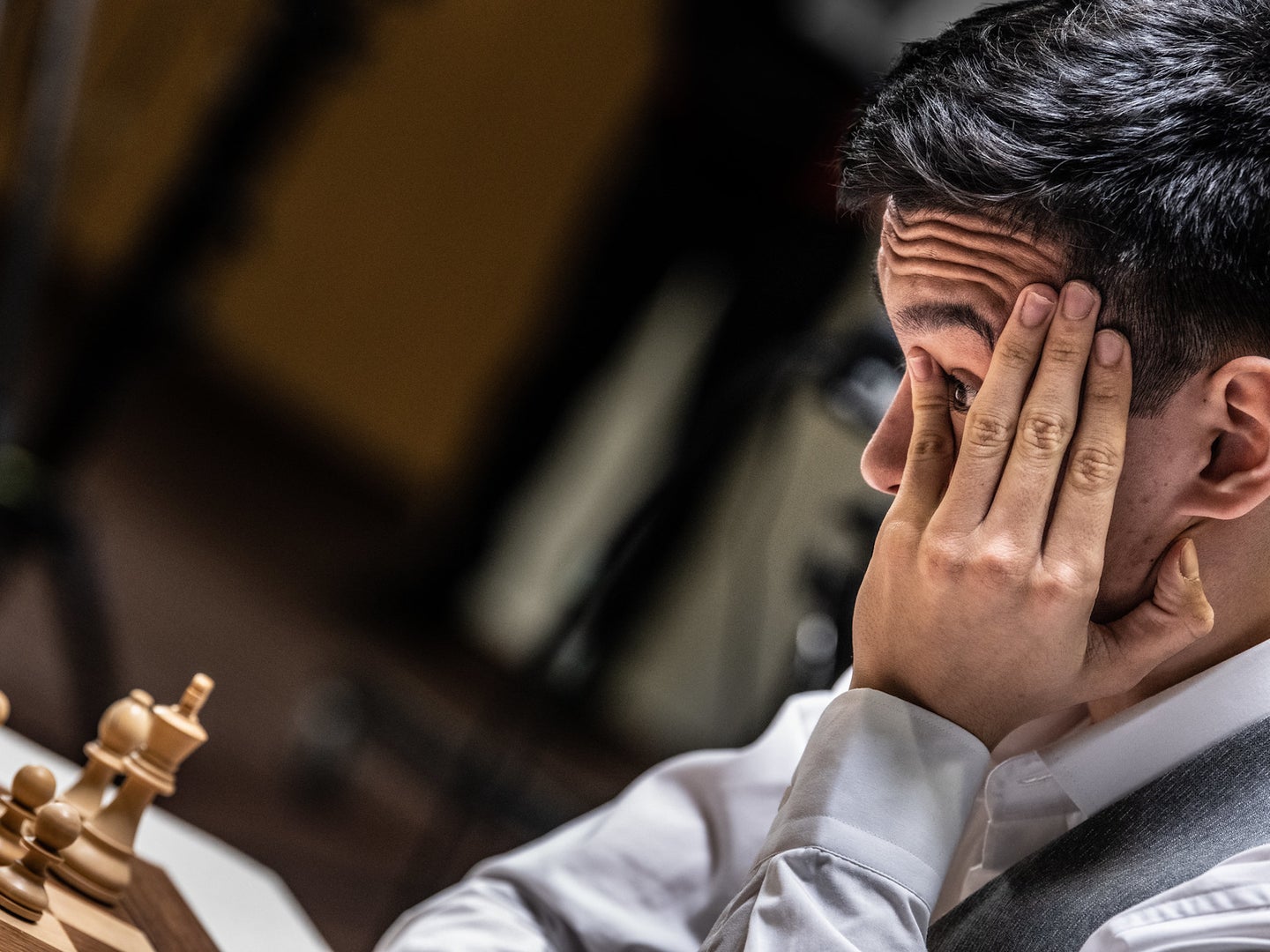 Close up of chess player with head in hand playing game