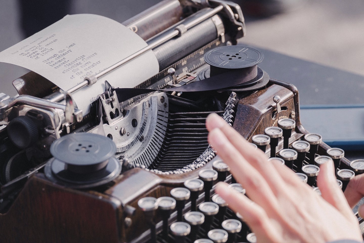 person's hand on typewriter