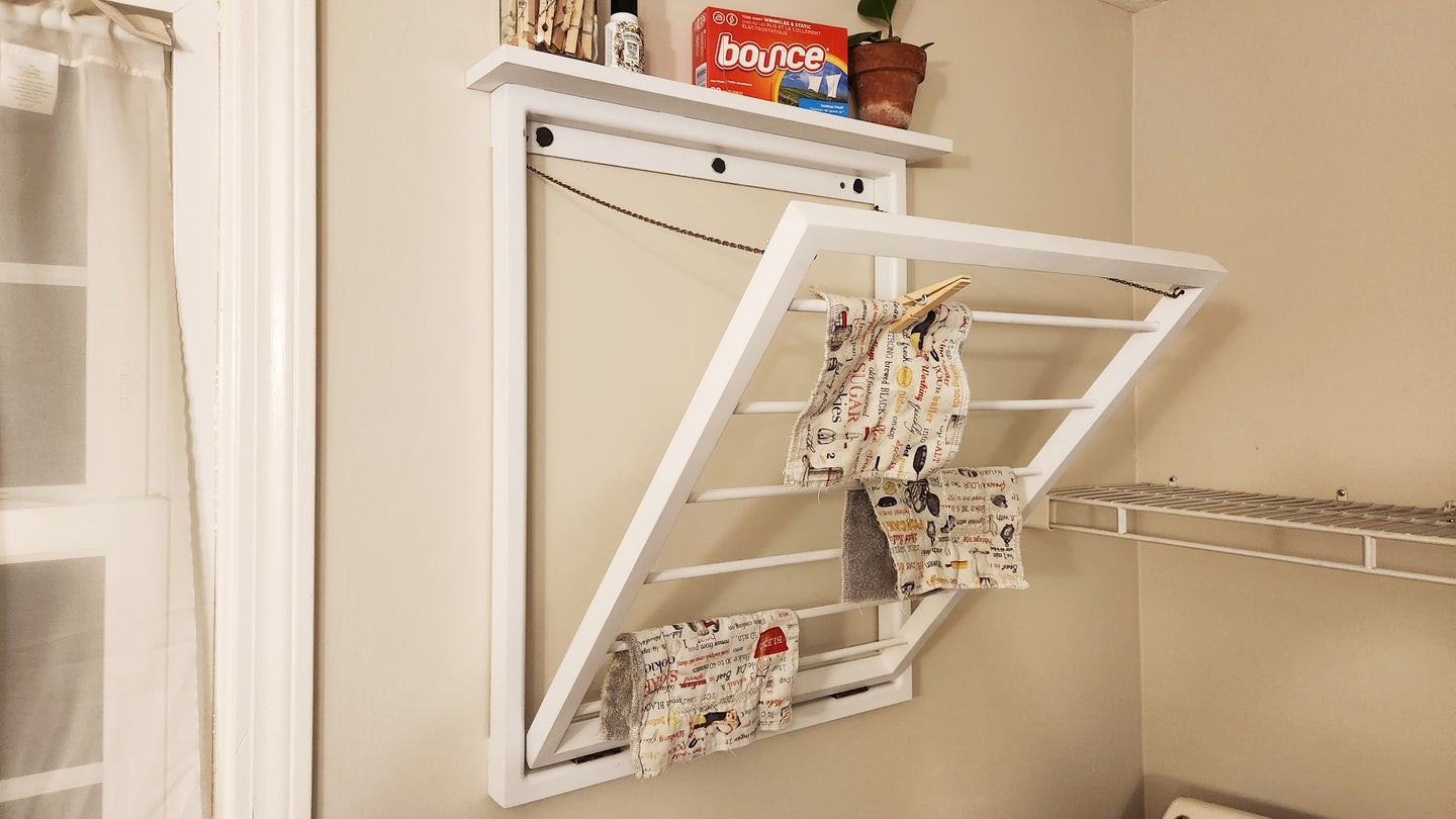 A DIY laundry drying rack mounted on a wall and in a folded-out position, ready to dry some clothes.