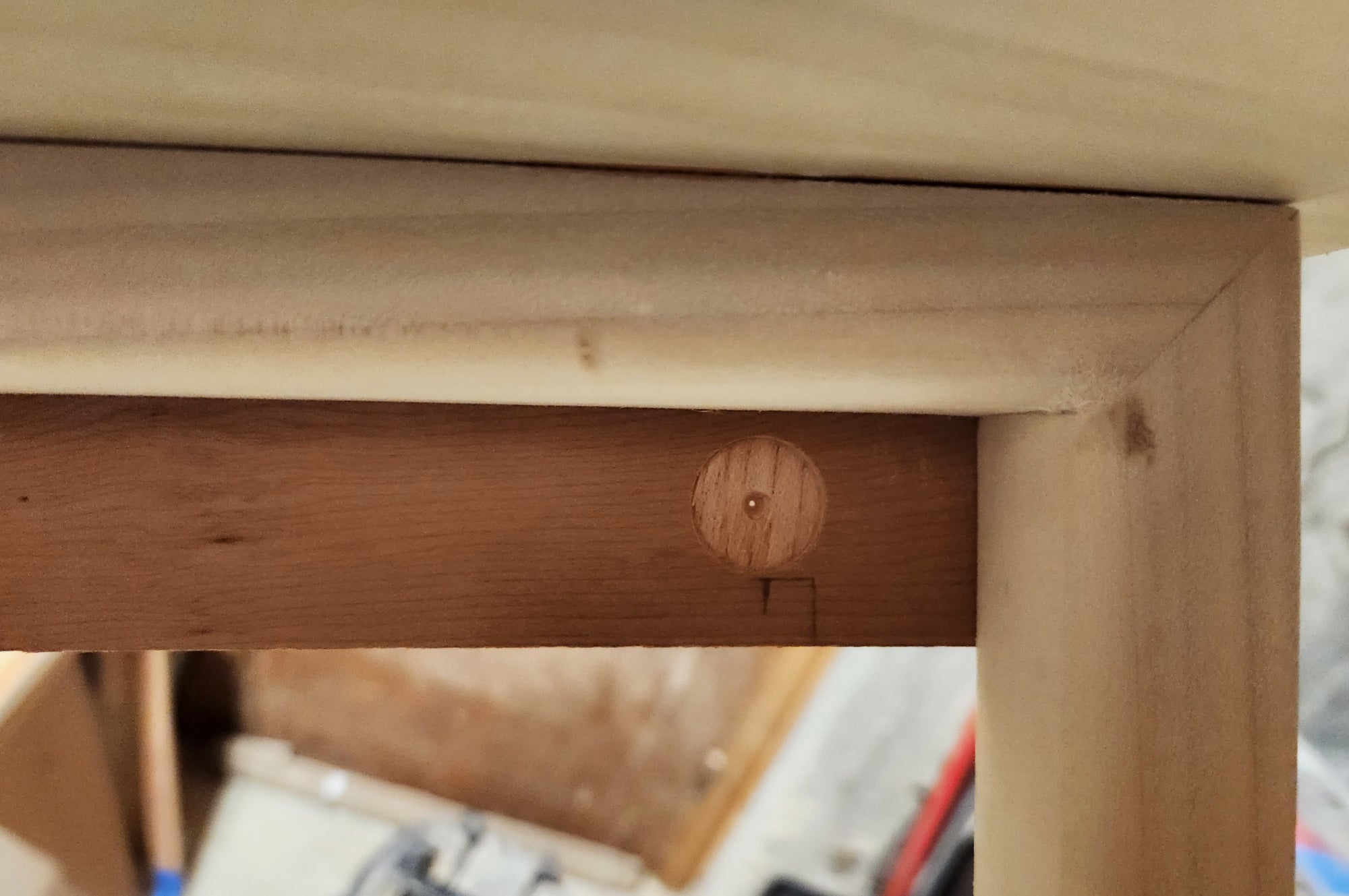 A shallow hole in a piece of wood on a DIY laundry drying rack, where a magnet will eventually go to hold the folding inner frame closed.