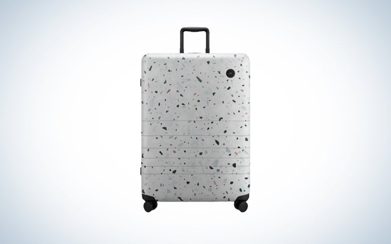 A Monos suitcase on a blue and white background