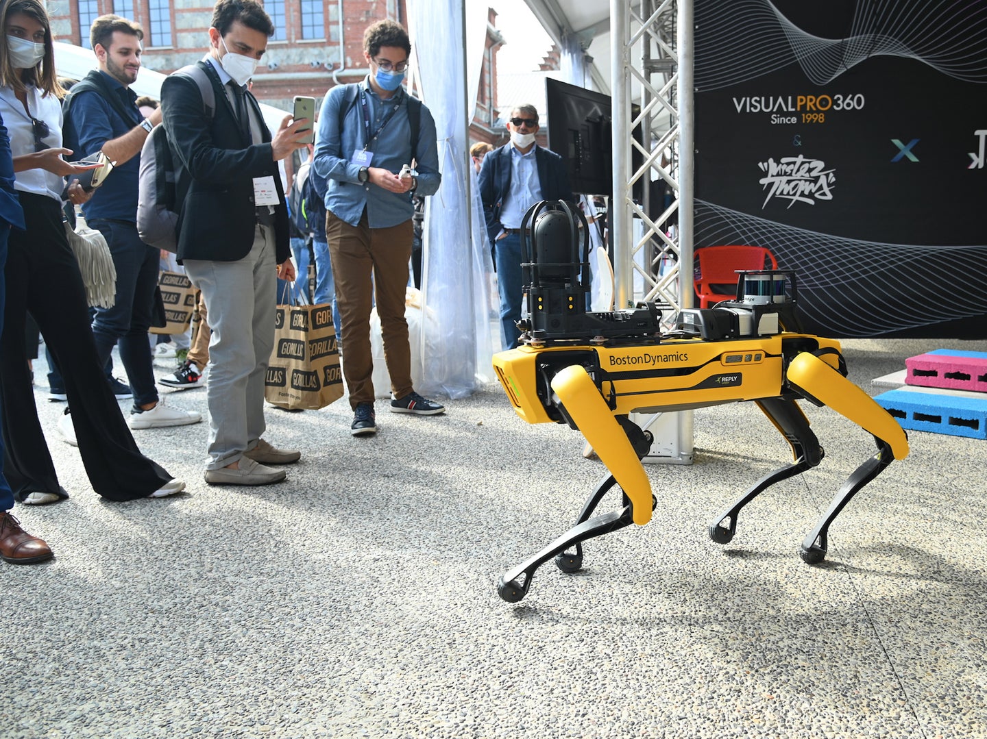 Onlookers film and photograph Boston Dynamics' Spot robot at a showcase