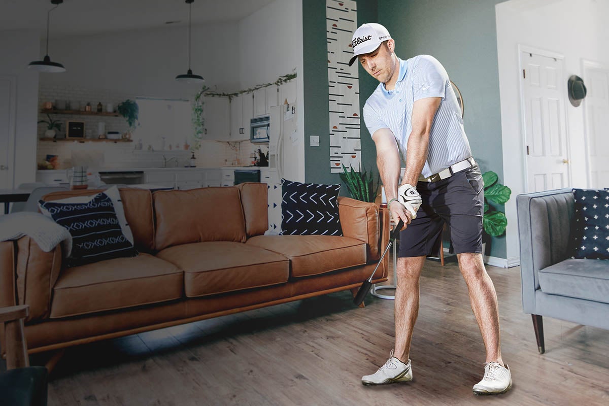 A person golfing indoors using a golf simulation program