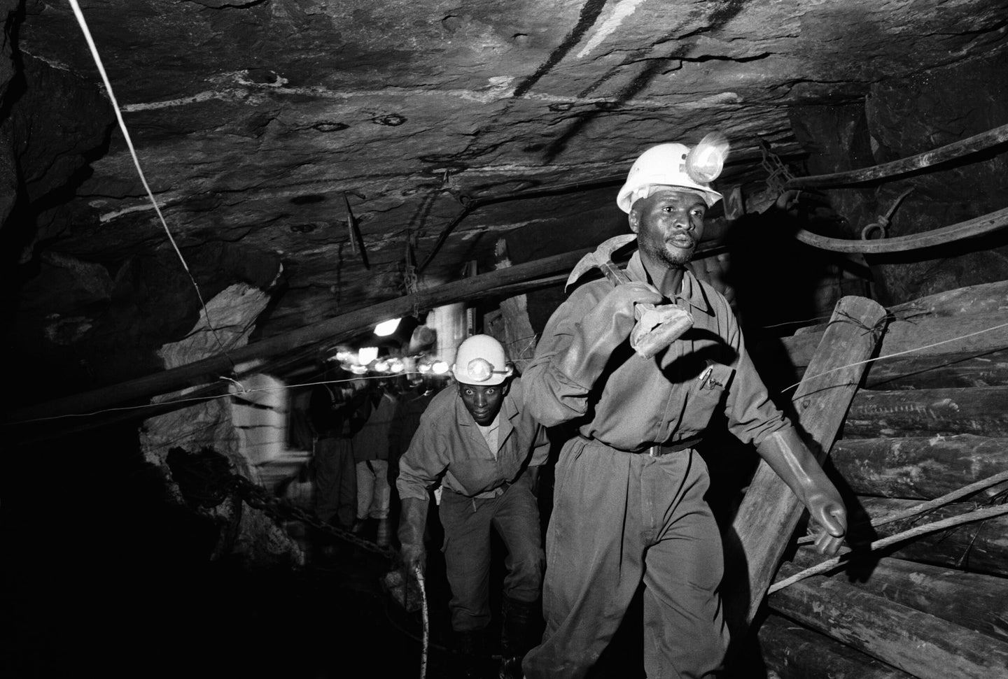 Miners working for the Lonmin Platinum company in South Africa walk along an underground tunnel in the early 2000s.
