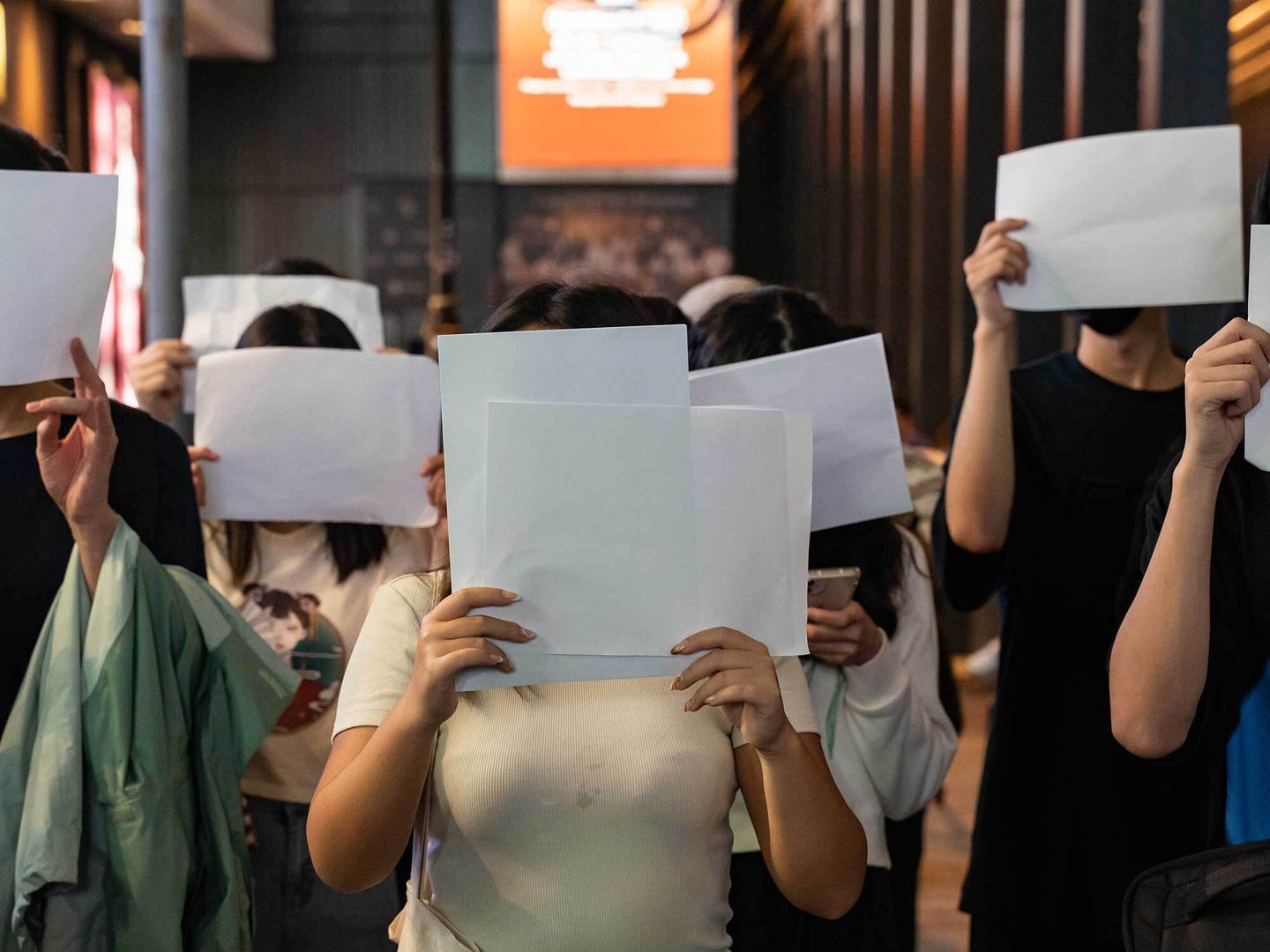 People hold sheets of blank paper in protest of COVID restriction in mainland as police setup cordon during a vigil in the central district on November 28, 2022 in Hong Kong, China.