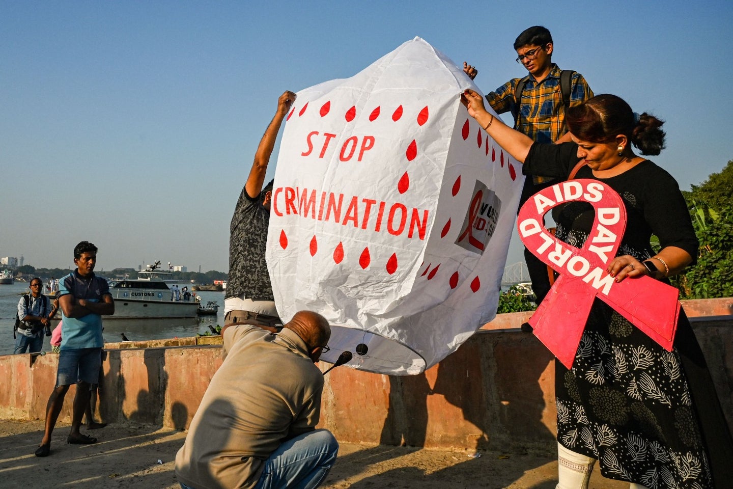 HIV/AIDS activists in India holding up "no discrimination" signs and red AIDS ribbons